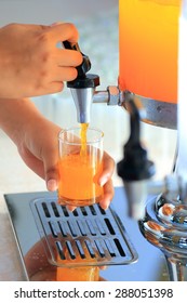 Status Hand Of Woman Push Orange Dispenser For Drink In Party