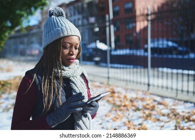 Status Update Winter Is Here. Shot Of A Beautiful Young Woman Using A Mobile Phone On A Snowy Day Outdoors.