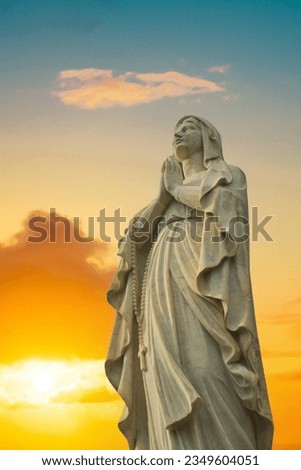 A statute of the Virgin Mary looking up while praying.