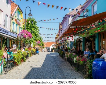 Stavanger, Norwegen - 22. Juli 2021: Touristen auf der historischen Straße in der Altstadt von Stavanger mit mehrfarbigen Holzhäusern.