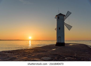 Stawa Mlyny, a beacon in the shape of a windmill as an official symbol of Swinoujscie at sunset