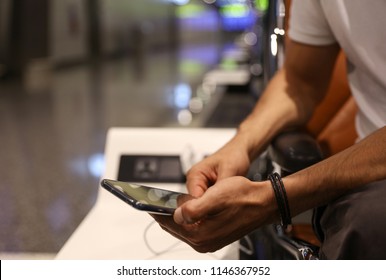 Stay Connected During Your Travel And Flight, Man Using Public Phone Charging Station At The Airport