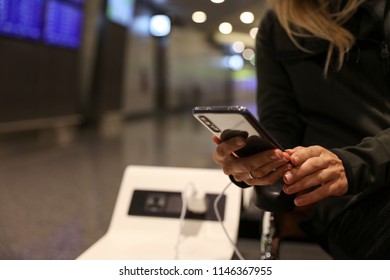 Stay Connected During Your Travel And Flight, Woman Using Public Phone Charging Station At The Airport