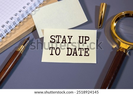 Stay Up To Date. text. Notepad, white sticker and pensil on the desk.