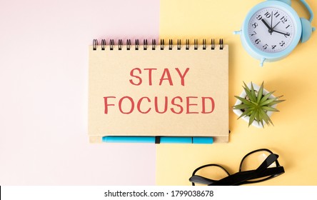 STAY FOCUSED man hand notebook and other office equipment such as computer keyboard - Powered by Shutterstock