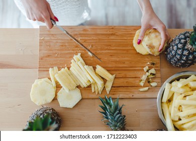 Stay Healthy At Home Concept. Pineapple Sliced By A Girl On The Kitchen Counter. Pineapples Are A Source Of Antioxidants, Reduce Risk Of Chronic Diseases, Heart Disease, Diabetes And Certain Cancers