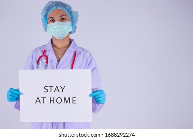 Stay At Home. Doctor In Medical Mask Holding White Paper With Text 