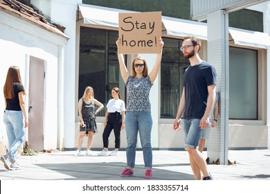 Stay home. Dude with sign - woman stands protesting things that annoy her. Solo demonstration right to talk free on the street with sign. Opinion heard by public. Social life, COVID, healthcare. - Shutterstock ID 1833355714