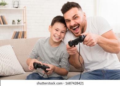 Stay At Home With Fun. Dad And Son With Joysticks Playing Video Games At Home, Free Space