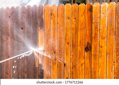Stay At Home House Repairs , Pressure Washing Fence With A High Pressure Washer , Cleaning Old Dirty Planks Of Wood On Wooden Fence In Suburb Neighborhood