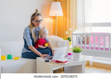 Stay At Home Mom Working On Laptop With Kid On Her Lap