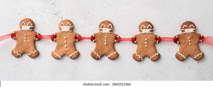 Stay home quarantine from Covid-19. Christmas gingerbread men with a masks - Shutterstock ID 1843315366