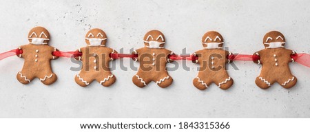 Stay home quarantine from Covid-19. Christmas gingerbread men with a masks