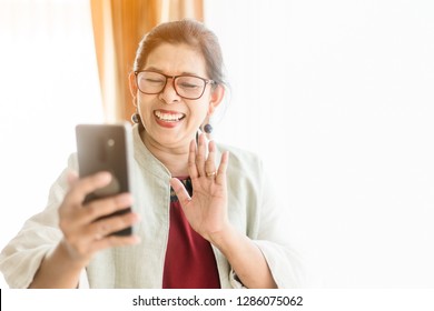 Stay home save lives from coronavirus covid-19.Self isolation.Happy smiley face senior elderly woman using smartphone video call conference camera and talking with family.Video chat social distancing. - Powered by Shutterstock