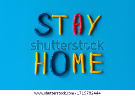 Stay home words from letters made of clay on a blue background, flat lay, background with text.