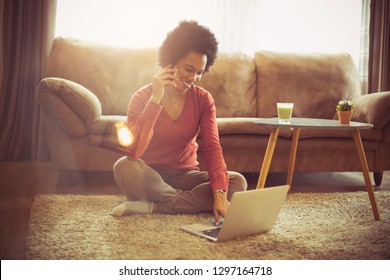 Stay In, Stay Connected. African American Woman At Home Using Laptop And Talking On Phone.