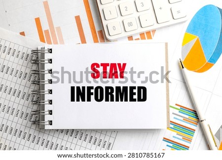Stay informed message on notepad with financial charts calculator and pen representing business analytics market research. 