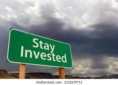 Stay Invested Green Road Sign Over Dramatic Clouds And Sky.