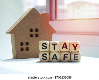 Stay safe concept. Word "Stay Safe" with wooden house near the window, stay at home, social media campaign for covid-19 or coronavirus pandemic prevention.