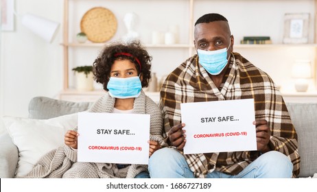 Stay Safe During Coronavirus Quarantine. African American Family Wearing Protective Masks At Home