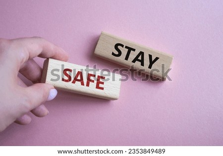 Stay Safe symbol. Concept word Stay Safe on wooden blocks. Businessman hand. Beautiful pink background. Business and Stay Safe concept. Copy space
