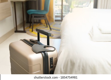 Stay Safe While Travel During Covid 19 Pandemic Concept. A Suitcase Or Baggage With A Medical Face Mask In The Hotel Room. Travel Bubbles, Business Trip, ASQ Alternative State Quarantine, New Normal.