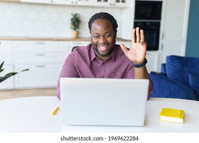 Stay In Touch With Work Team During Quarantine. African-American Guy Using Laptop For Video Connection, Waving Hi Into Webcam, Involved Video Meeting With Colleagues, Greeting Participants Online