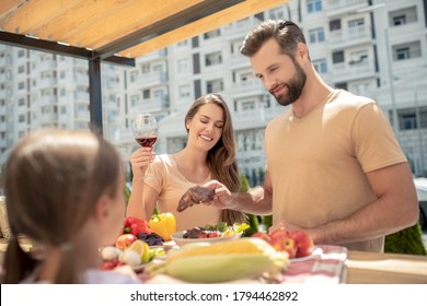 Staycation. Oung Cute Family Having Dinner Outside And Looking Contented