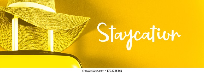 Staycation Word. Cabin Size Suitcase With Straw Hat Against Bright Blue Background. Easy Travel At Home Country During Coronavirus Outbreak With Little Baggage Concept. Banner, Toned In Yellow