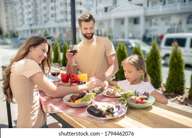 Staycation. Young Family Having Dinner Outside And Looking Happy