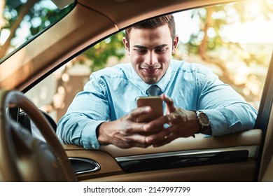 Staying close to his network even when on the go. Shot of a young businessman using a cellphone while leaning against his car.