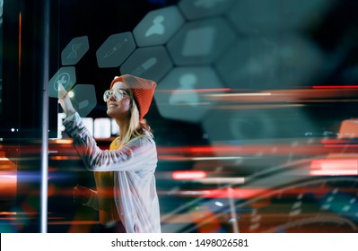 Staying up to date with technology in a fast moving world. A beautiful young millennial woman is using a digital holographic panel next to the road to check for online medical services. - Powered by Shutterstock