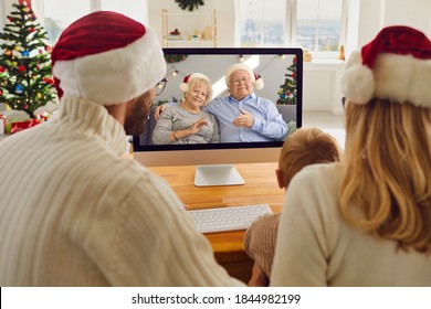 Staying at home but keeping in touch with family. Mom, dad and little son video calling grandparents on Christmas holidays. Happy grandma and grandpa talking to their grandchild who they miss so much - Powered by Shutterstock