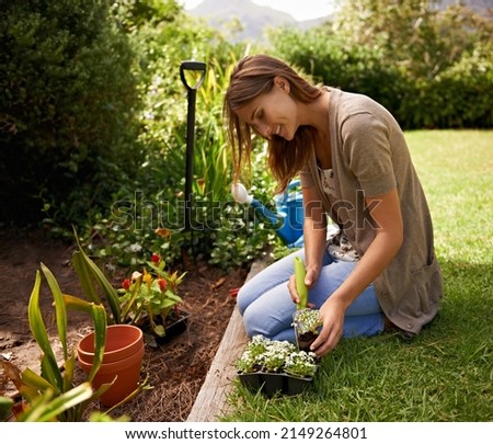 Staying in touch with her inner gardner. A young woman gardening.