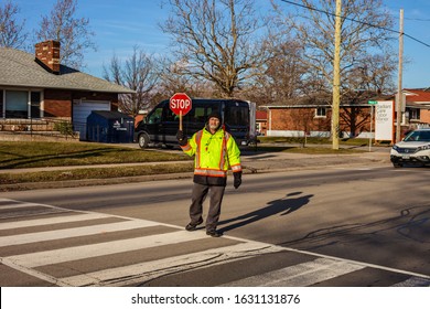 St.Catharines. Ontario/Canada-01.29.2020 Eighty Year Old Crossing Guard.  Older People Always Stay  Young. Children Cross The Street After School. Follow The Rules Of The Road. Pensioners Help Childre