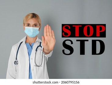 STD Prevention. Doctor In Protective Mask Showing Stop Gesture On Grey Background