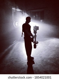 A Steadicam Camera Operator In The Backlight On The Film Set With A Cinema Camera.