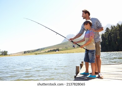 Steady Now. Shot Of A Father And Son Fishing On A Dock.