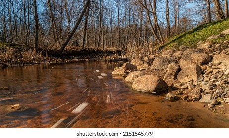 A Steady Stream Of Water In The Creek And Stones.