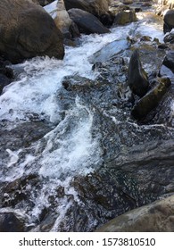 A Steady Stream Of Water In Hard Rock Background