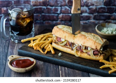 A Steak And Blue Cheese Hoagie Sandwich Served With Fries And Cola.