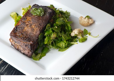 Steak Braised In Organic Butter, Garlic And Served  With Jumbo Lump Crab Cake, Cauliflower, Broccoli And Potatoes. Classic American Steakhouse Restaurant Or French Bistro Entree Favorite.