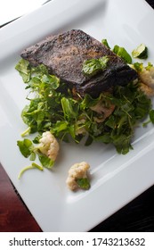 Steak Braised In Organic Butter, Garlic And Served  With Jumbo Lump Crab Cake, Cauliflower, Broccoli And Potatoes. Classic American Steakhouse Restaurant Or French Bistro Entree Favorite.