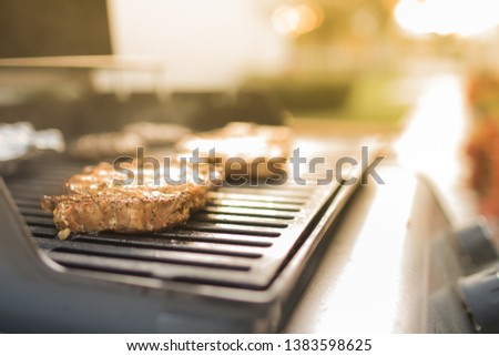 Steak cooking gass grill in a backyard home setting
