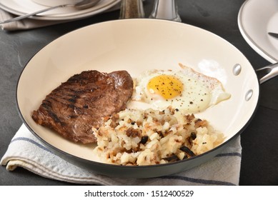 Steak And Eggs With Hashbrowns In A Skillet On A Breakfast Table