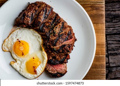 Steak and Eggs. Steak, served medium rare with eggs scrambled or sunny side up, toast and coffee. Traditionally classical American or French Bistro breakfast or brunch favorite: steak and eggs. - Powered by Shutterstock