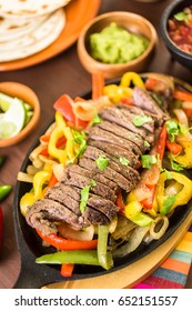 Steak Fajitas With Bell Peppers And Yellow Onion On A Cast Iron Fajita Skillet.