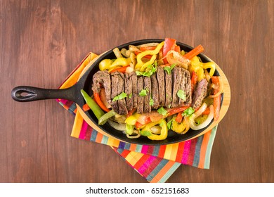 Steak Fajitas With Bell Peppers And Yellow Onion On A Cast Iron Fajita Skillet.