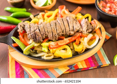 Steak Fajitas With Bell Peppers And Yellow Onion On A Cast Iron Fajita Skillet.