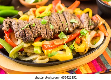 Steak Fajitas With Bell Peppers And Yellow Onion On A Cast Iron Fajita Skillet.